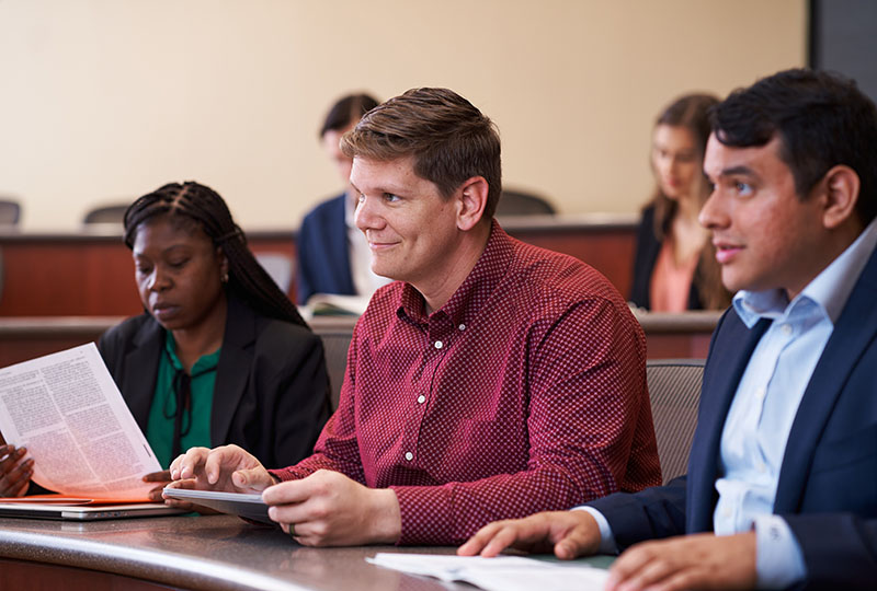 three people sitting in a meeting