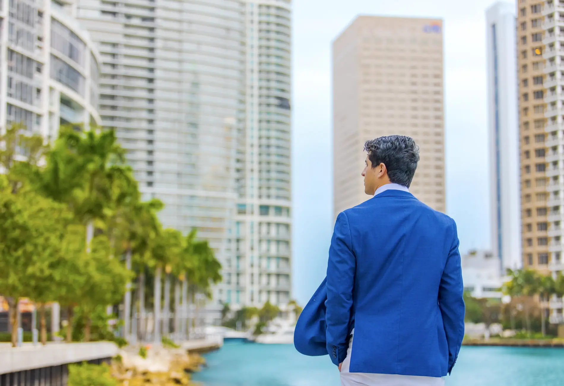Business student in blue jacket look at water on UM campus