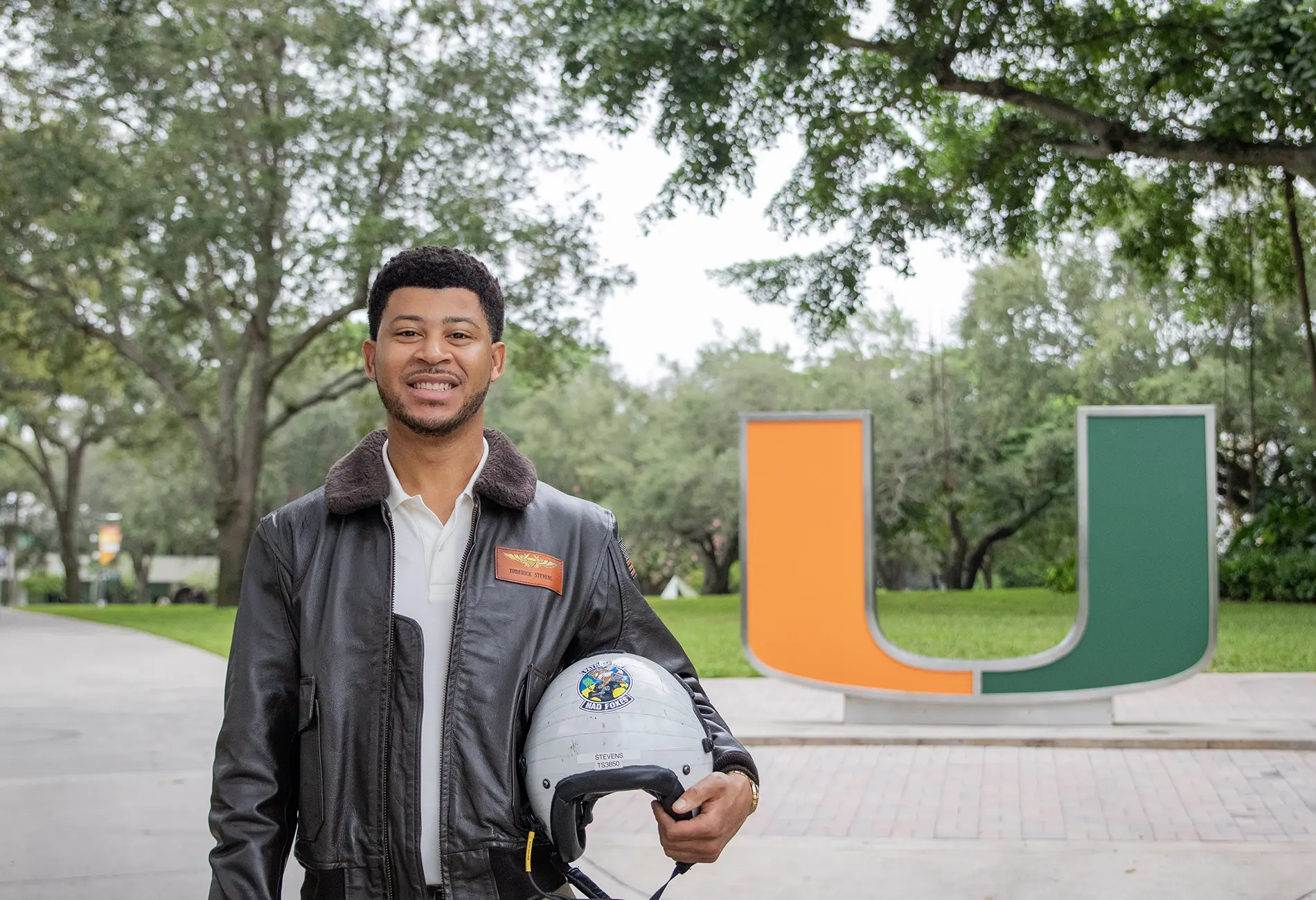 A student veteran holding a military helmet