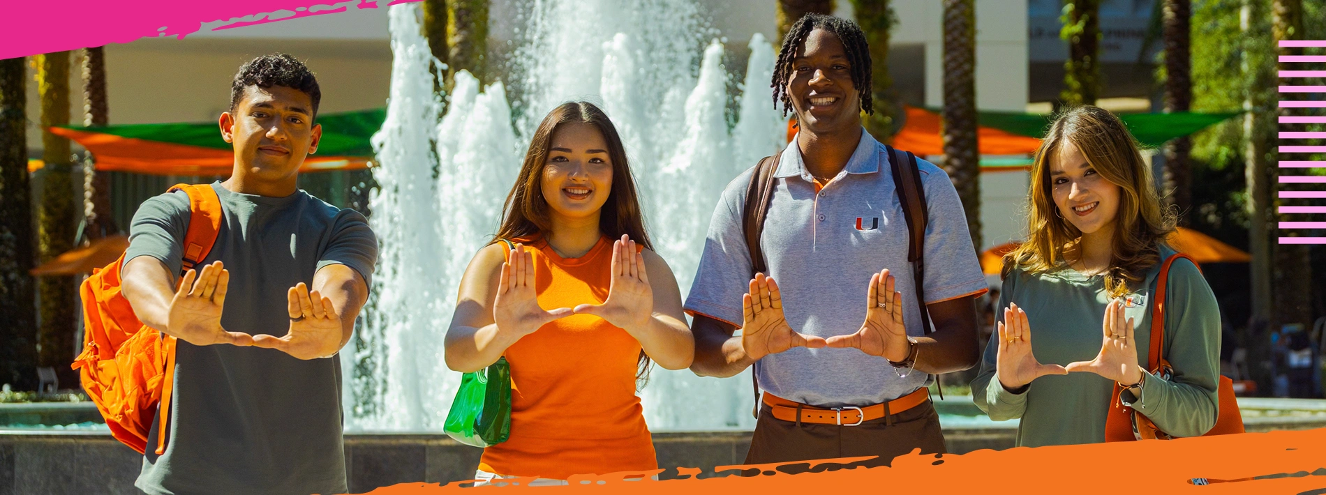 Group of students throwing up the U sign at the Miami Herbert Business School